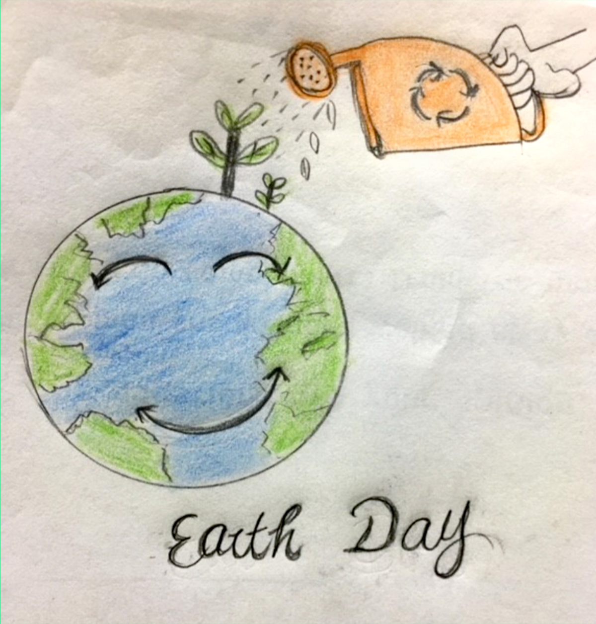 Hand holding an orange watering can with a recycling symbol on it and pouring water over a smiling planet earth