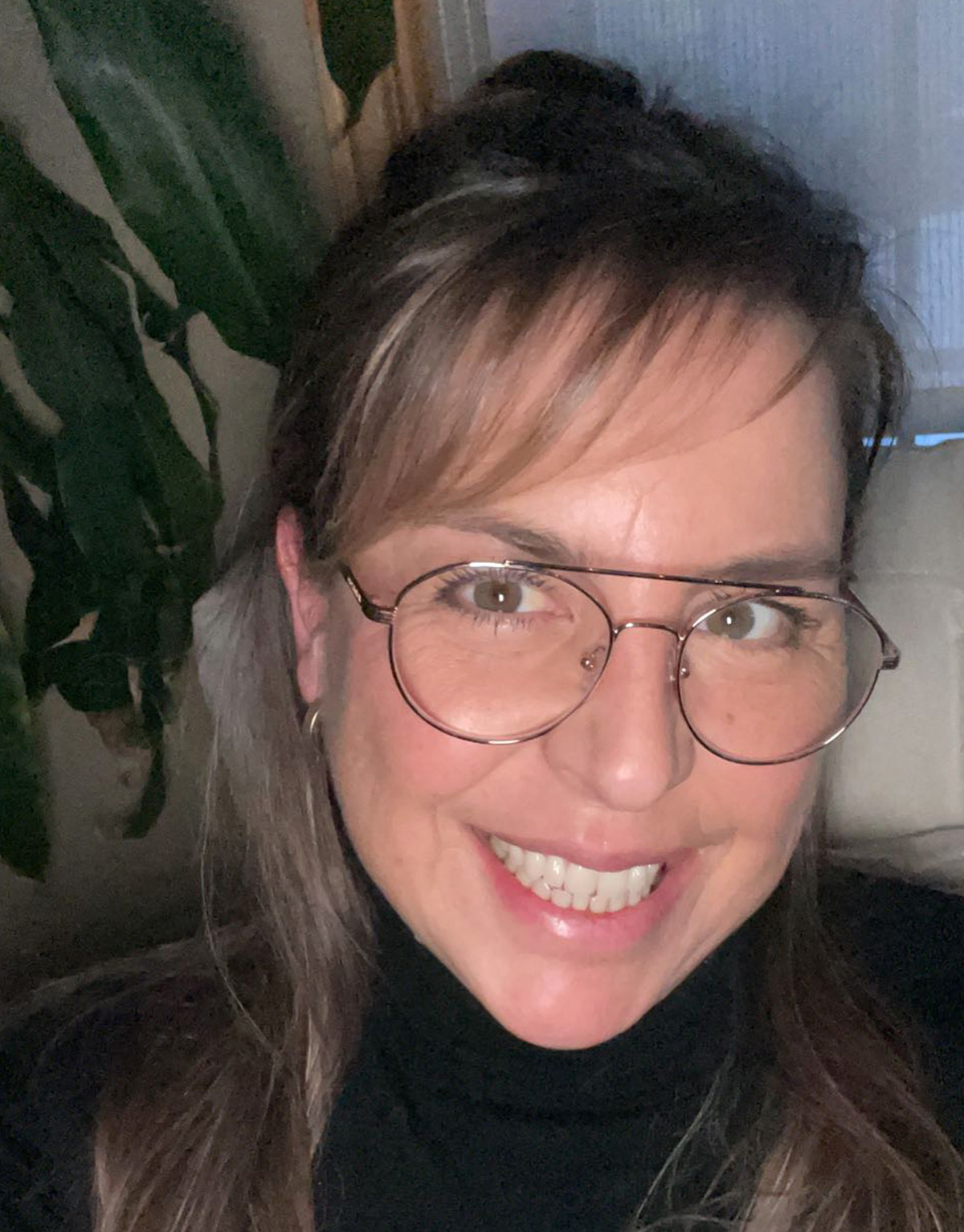 Sophie Collin, a smiling middle-aged woman with side-swept bangs and round metal-framed glasses.